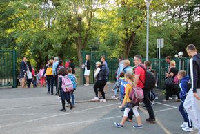 Parents et enfants entrent dans l'élémentaire du pérollier le jour de la rentrée.